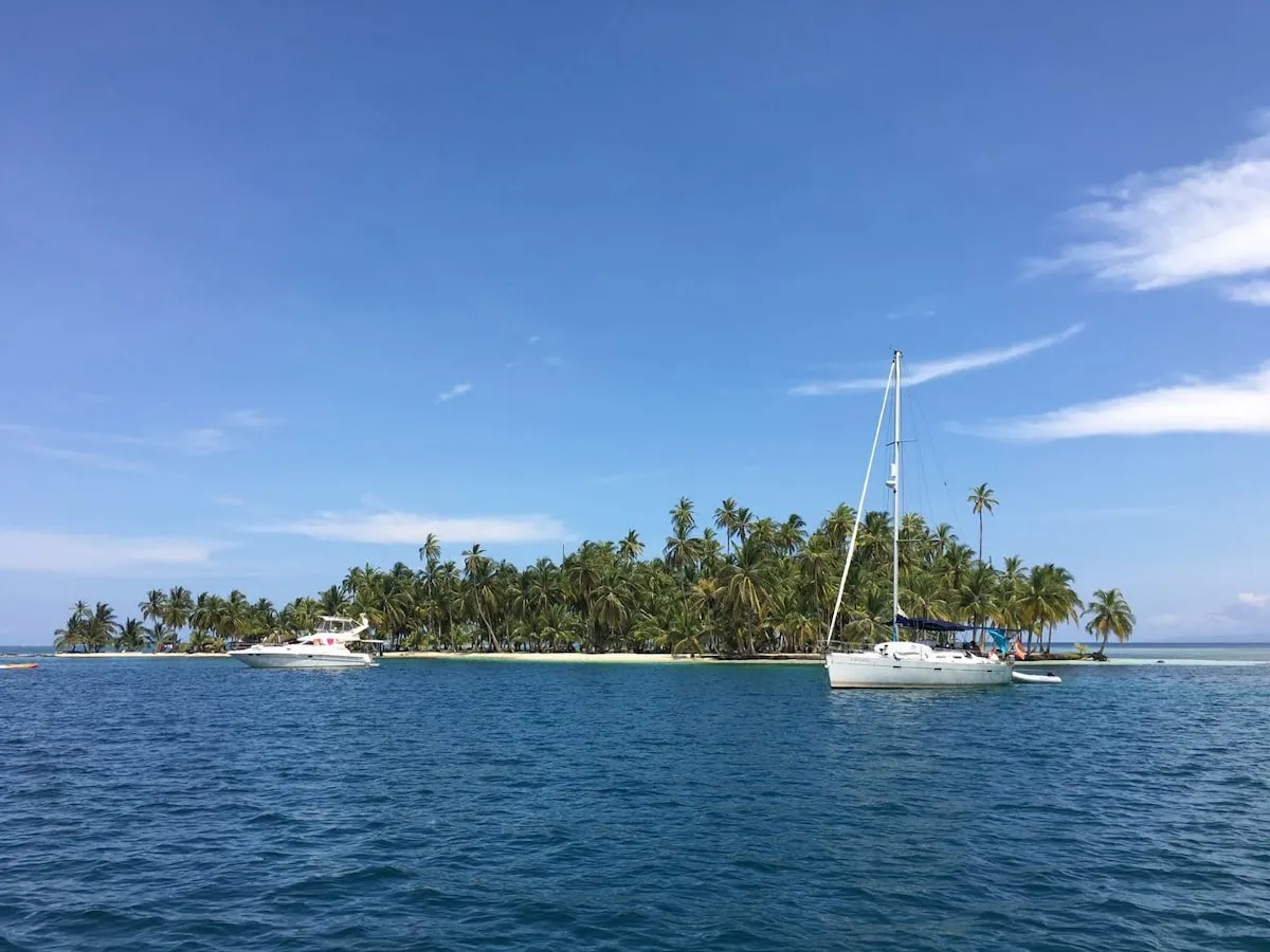 Sailboat near a small tropical island in clear water